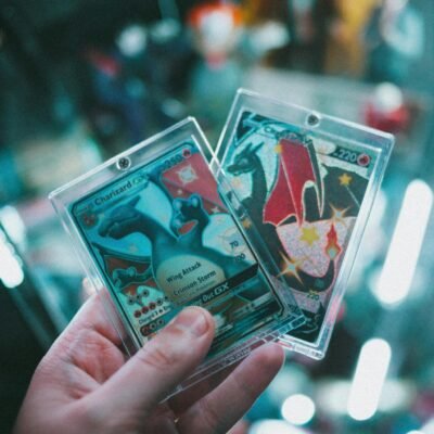 Close-up image of a hand holding colorful trading cards with a blurred background.